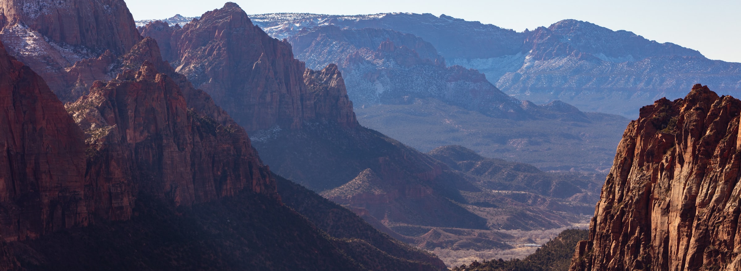Sunset over a Utah mountain ridge with cloud-streaked sky — outdoor landscape backdrop for the Nomatic Atlas app